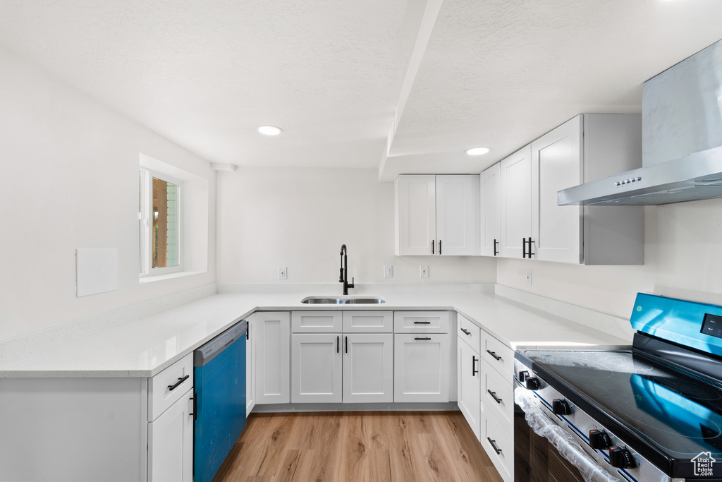 Kitchen featuring electric stove, wall chimney range hood, dishwashing machine, recessed lighting, and light wood-style flooring