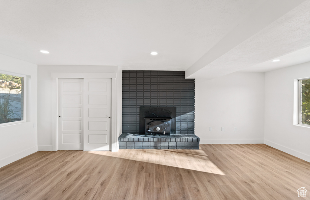 Unfurnished living room featuring wood finished floors, recessed lighting, and a fireplace