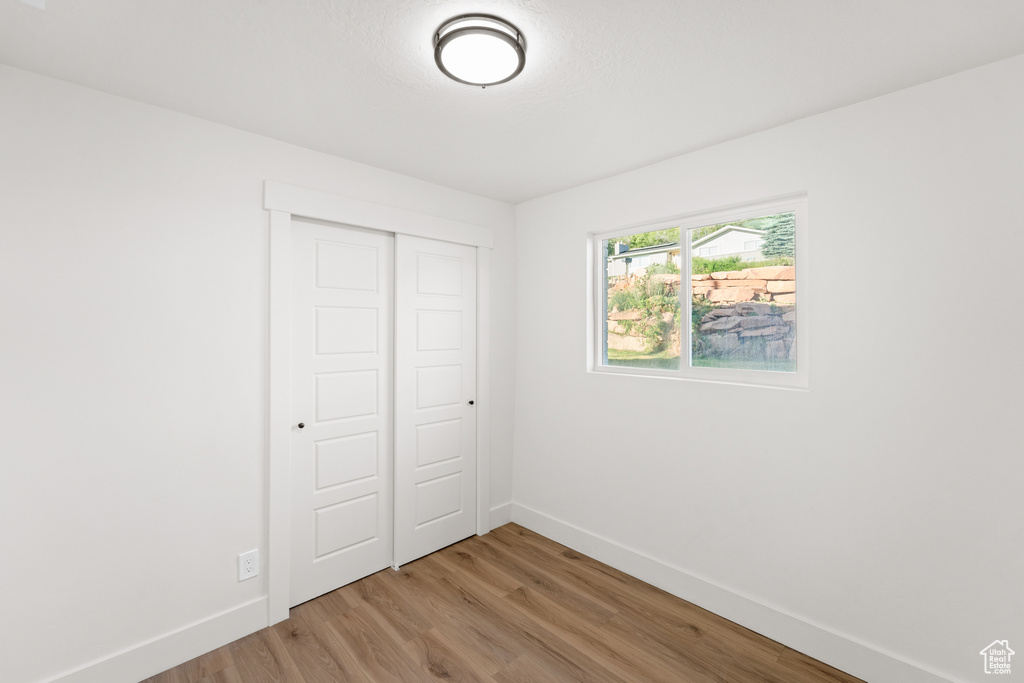 Unfurnished bedroom with light wood-type flooring and a closet