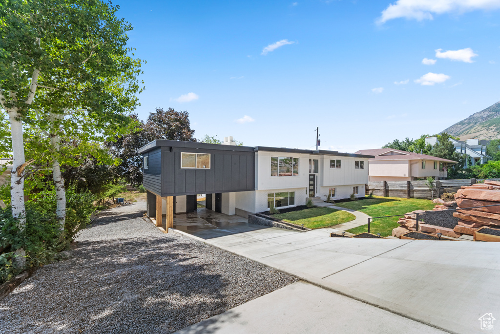 Split foyer home with concrete driveway and a carport
