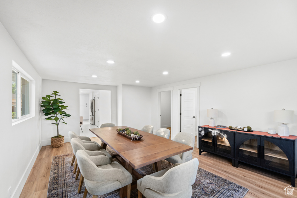 Dining room with light wood-type flooring and recessed lighting