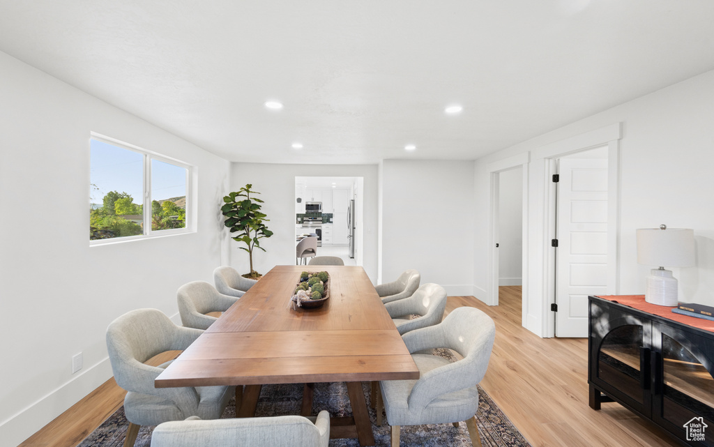 Dining area with light wood finished floors and recessed lighting