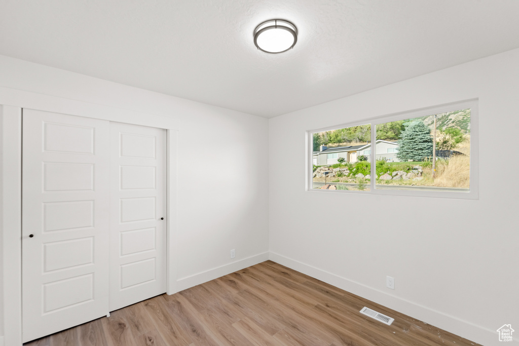 Unfurnished bedroom featuring light wood-type flooring and a closet