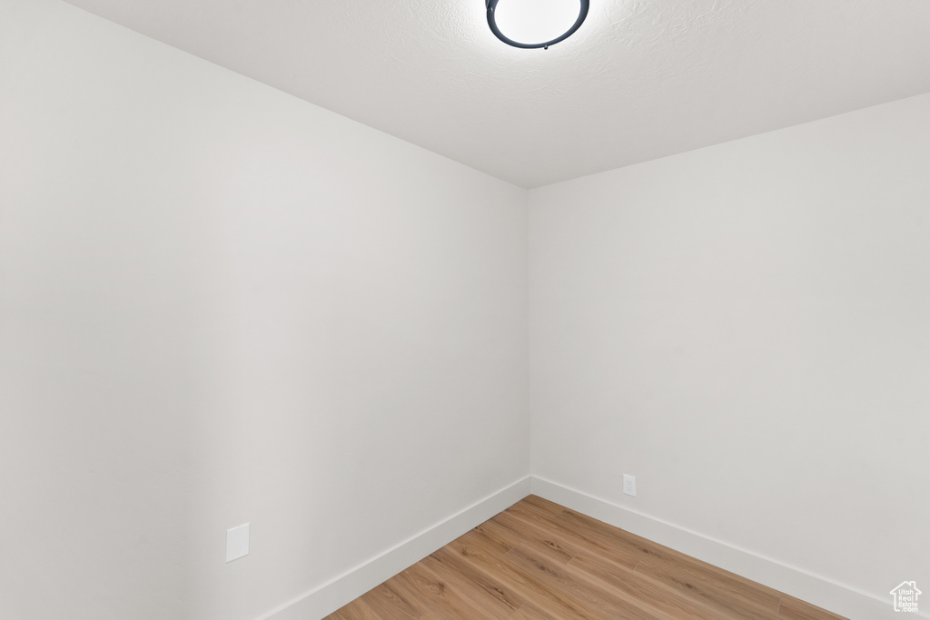 Spare room featuring baseboards and light wood-style flooring