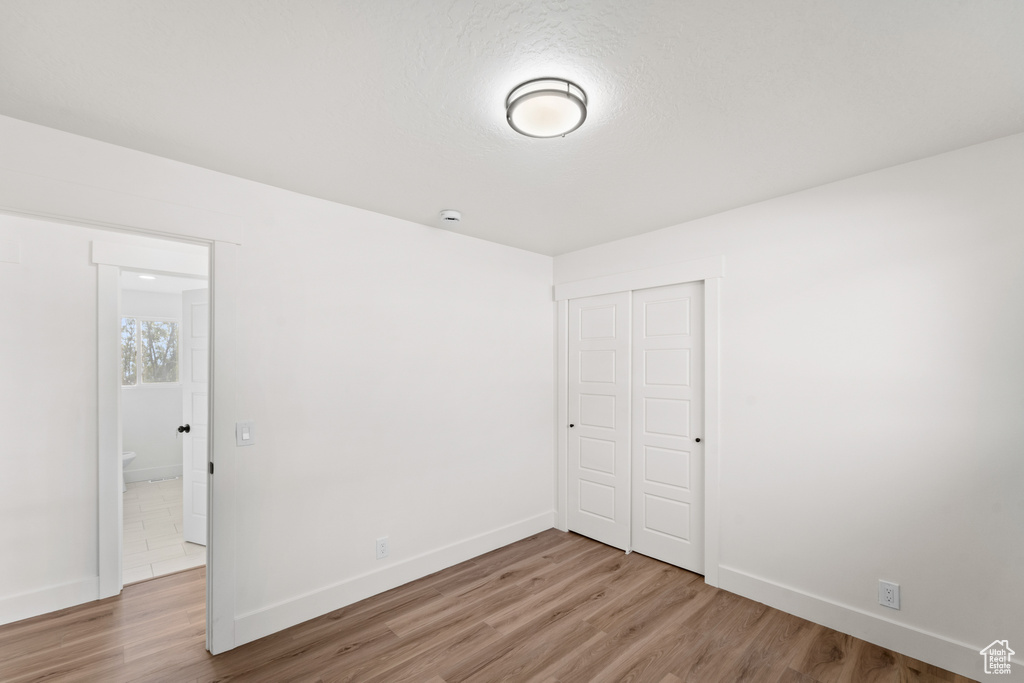 Unfurnished bedroom featuring wood finished floors and a closet