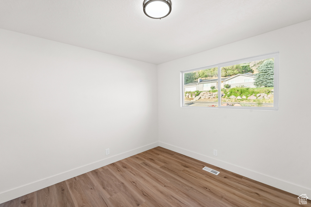 Empty room with baseboards and light wood-style flooring