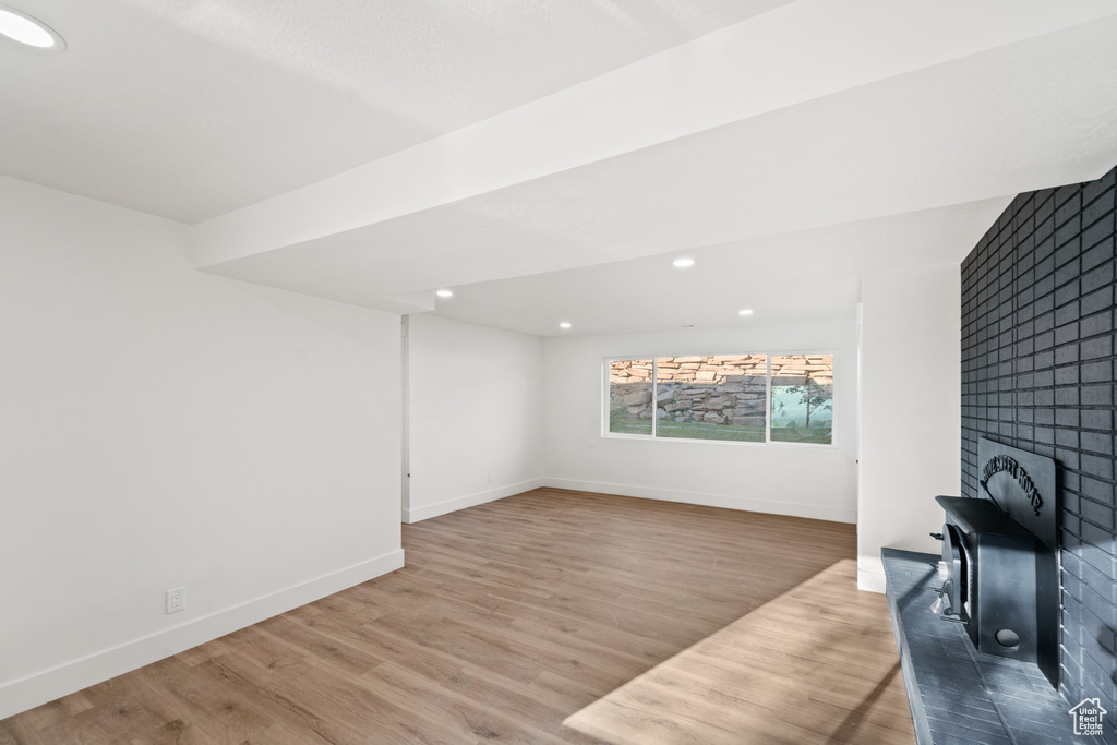 Unfurnished living room featuring wood finished floors, recessed lighting, and a fireplace