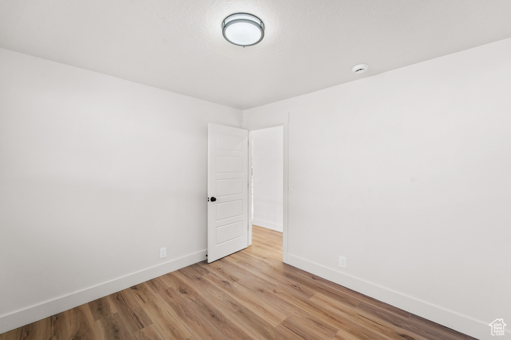Spare room with light wood-style flooring and a smoke detector