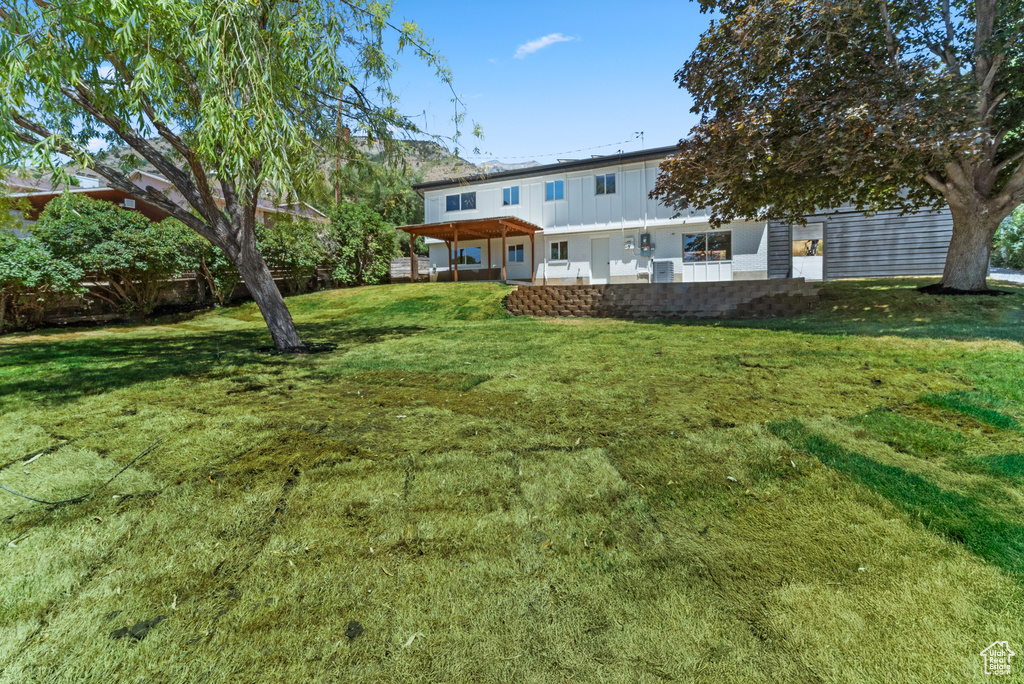 Rear view of house with a yard and a patio
