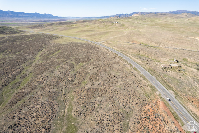 Aerial view of property and surrounding area with a mountainous background and rural landscape