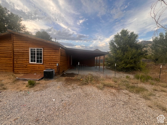 View of side of home with a carport and driveway