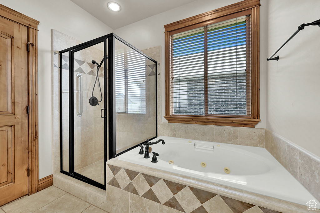 Full bath with a tub with jets, a stall shower, and tile patterned flooring