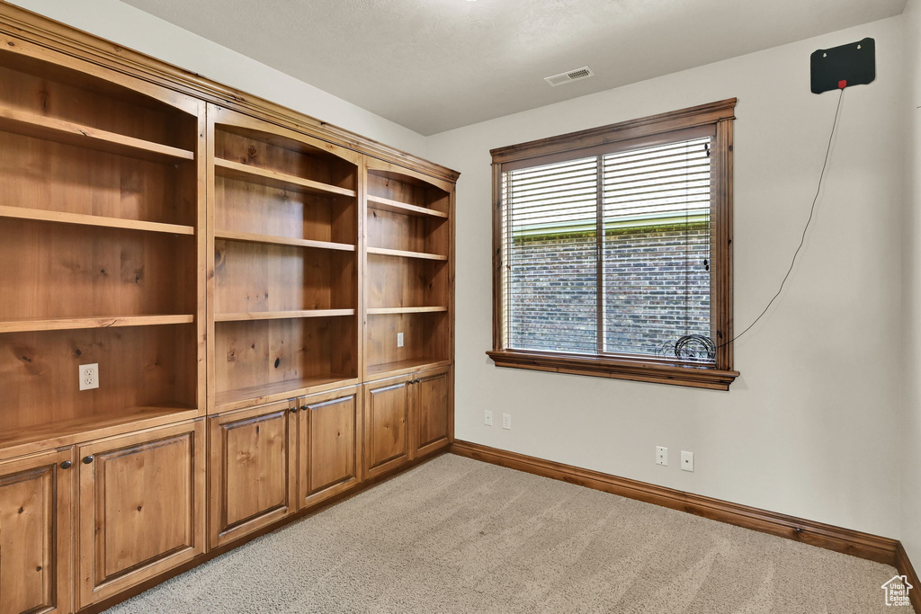 Empty room featuring light carpet and baseboards