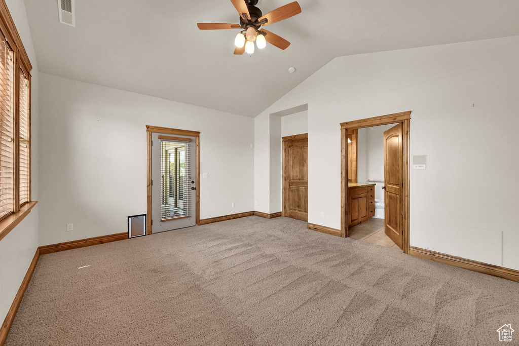 Unfurnished bedroom featuring light carpet, access to outside, connected bathroom, ceiling fan, and high vaulted ceiling