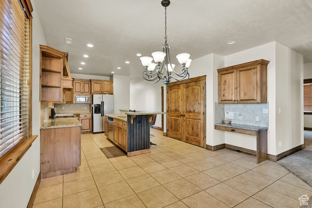 Kitchen featuring appliances with stainless steel finishes, open shelves, light tile patterned flooring, backsplash, and recessed lighting