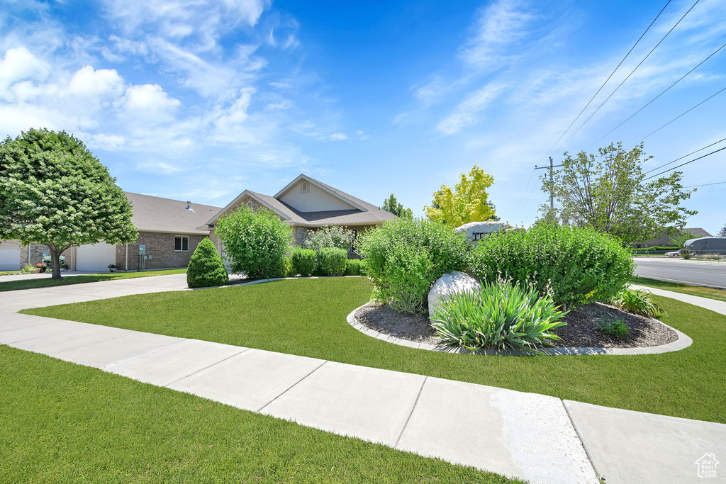 View of front of property featuring a front lawn and concrete driveway