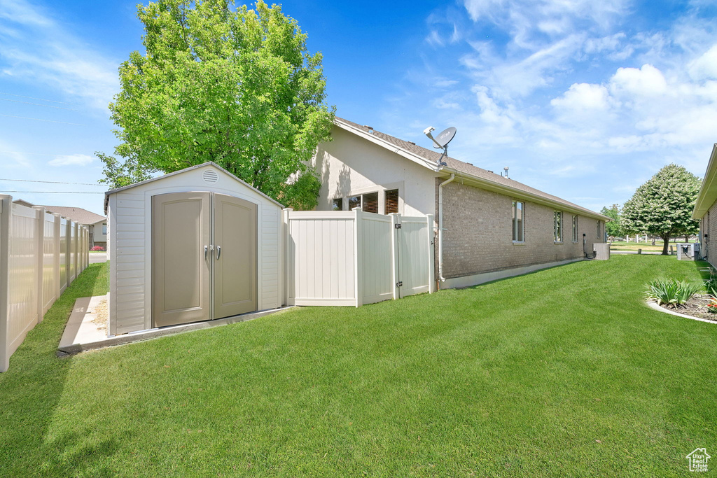 Rear view of house featuring a storage unit and brick siding