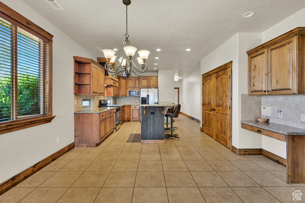 Kitchen featuring stainless steel appliances, open shelves, a chandelier, recessed lighting, and decorative backsplash