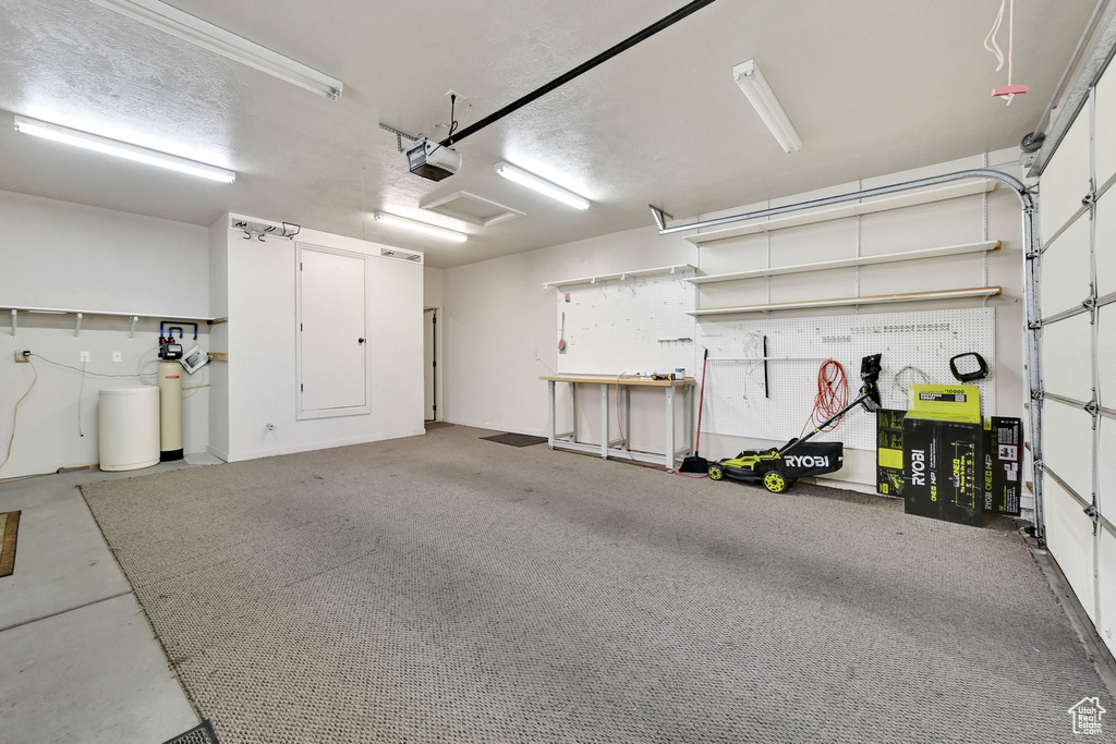 Garage featuring a garage door opener and a workshop area