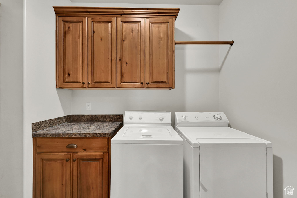 Washroom with cabinet space and washing machine and dryer