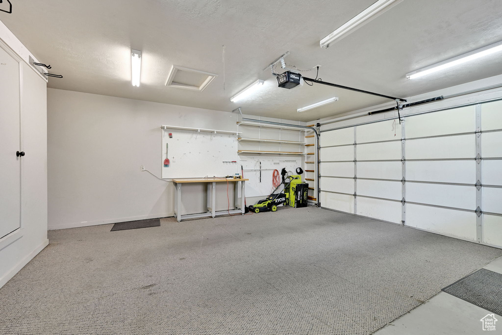 Garage with a garage door opener and a workshop area