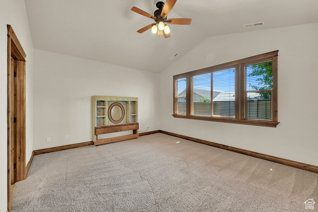 Unfurnished room with light colored carpet, ceiling fan, and lofted ceiling