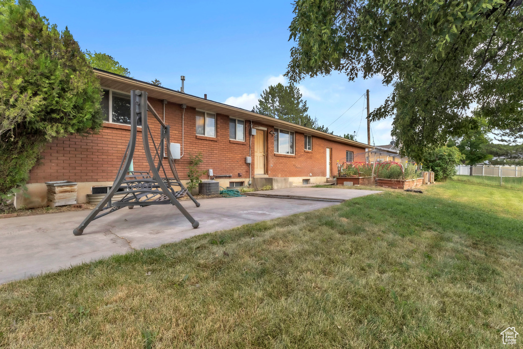 Back of property with brick siding, a patio, and a garden