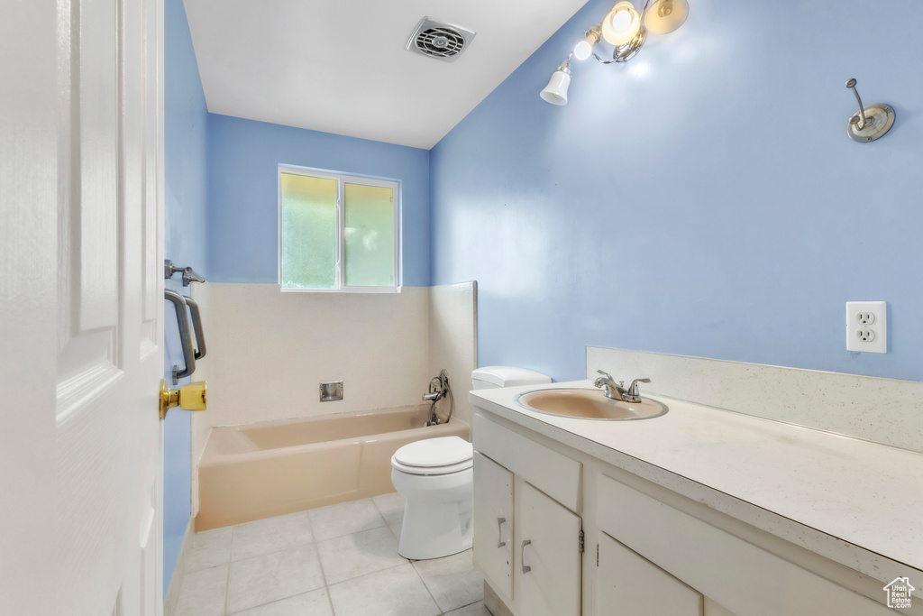 Full bath featuring a bathtub, vanity, and tile patterned flooring