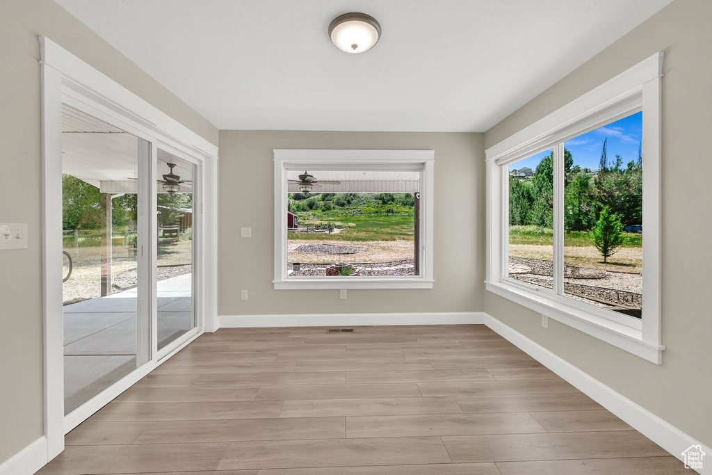 Empty room featuring light wood finished floors and ceiling fan