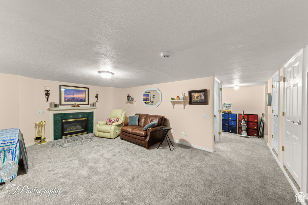 Carpeted living room featuring a textured ceiling and a high end fireplace