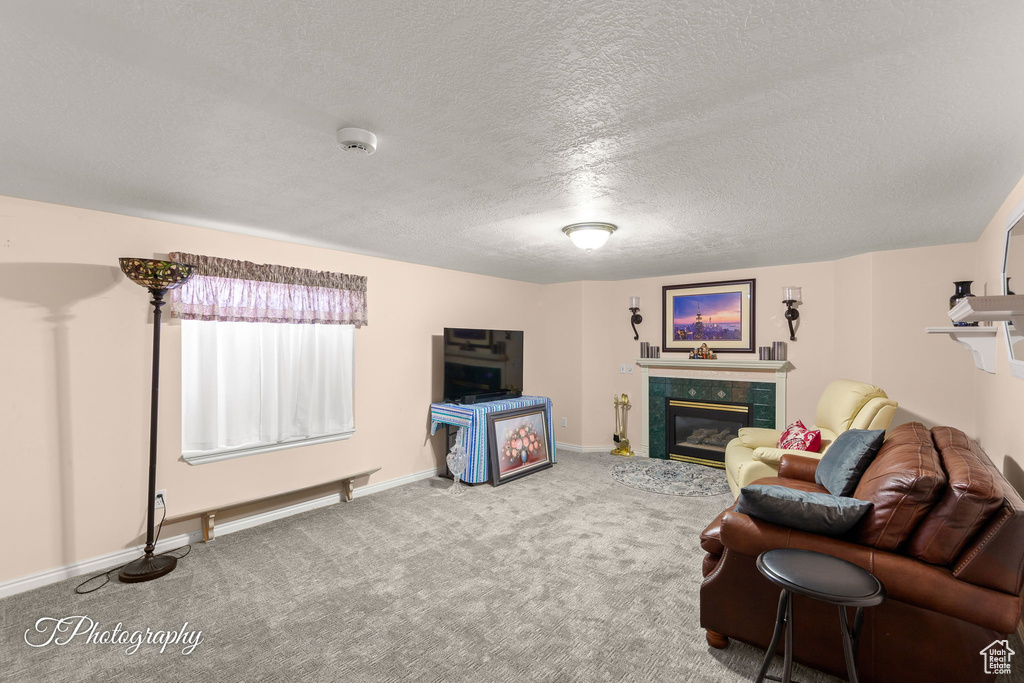 Carpeted living area featuring a fireplace and a textured ceiling
