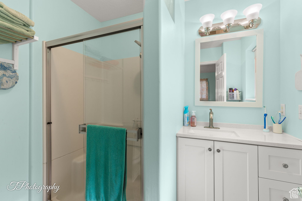 Bathroom featuring a shower stall and vanity