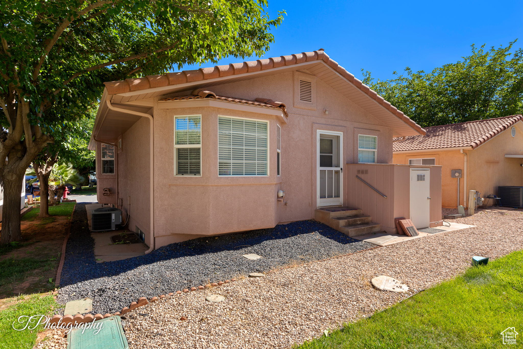 Back of property featuring stucco siding and a tile roof