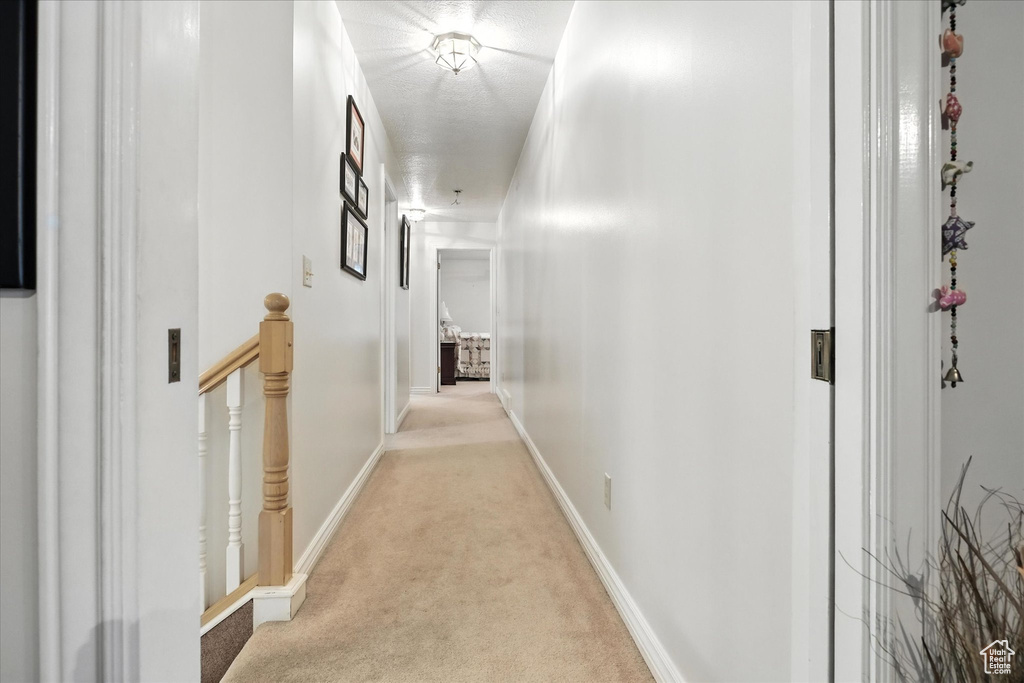 Corridor featuring light carpet and an upstairs landing