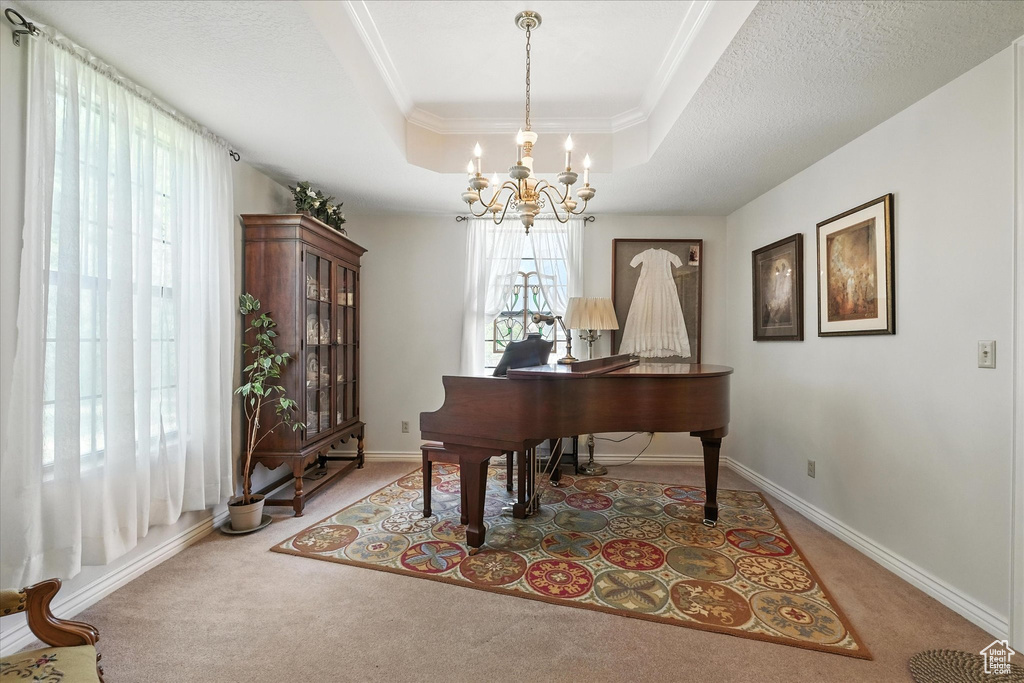 Sitting room with light carpet, a raised ceiling, a chandelier, and crown molding