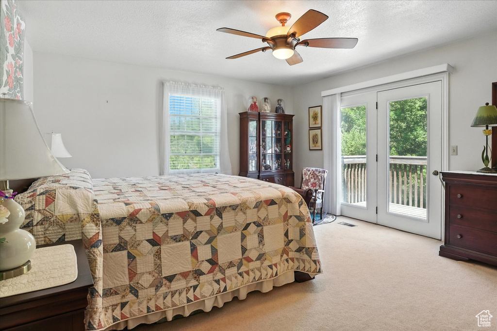 Carpeted bedroom featuring access to outside and a ceiling fan