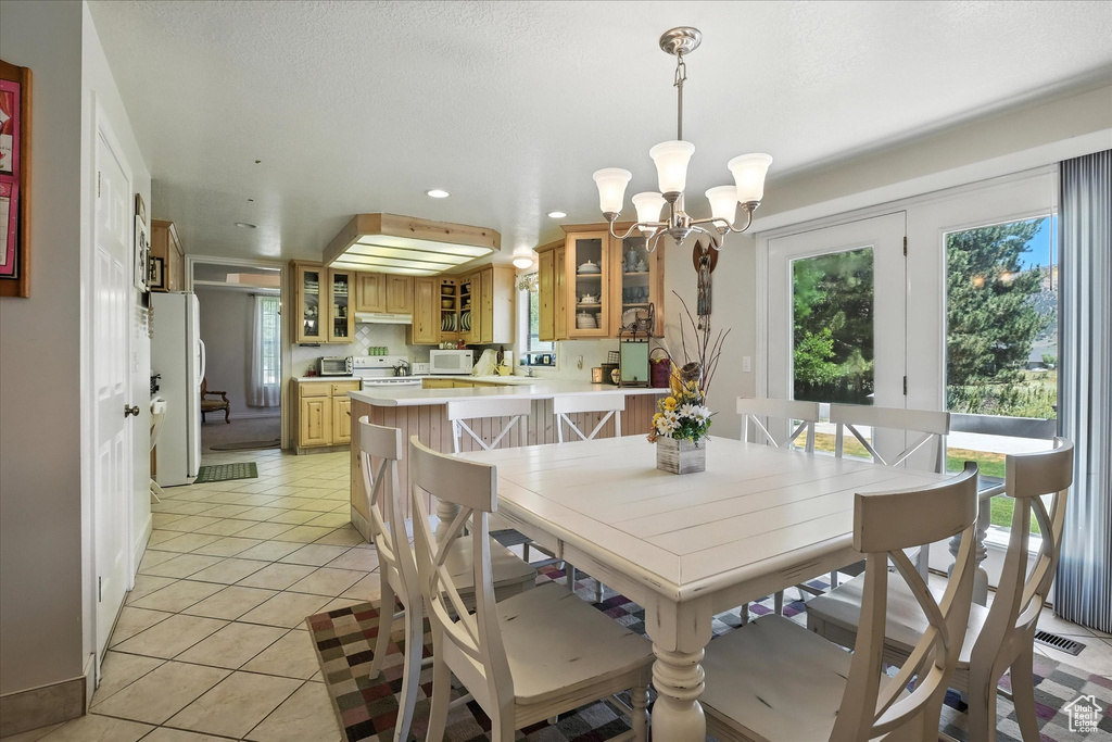 Dining room with recessed lighting, a chandelier, and light tile patterned floors