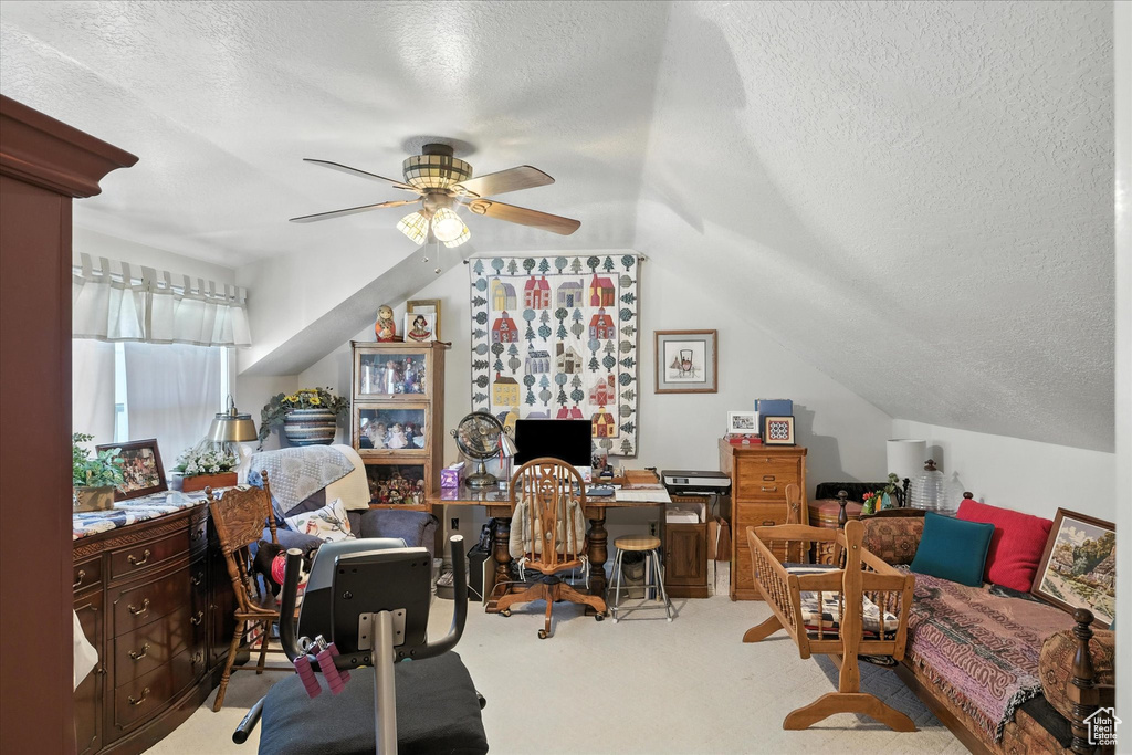 Carpeted office with a textured ceiling, a ceiling fan, and lofted ceiling