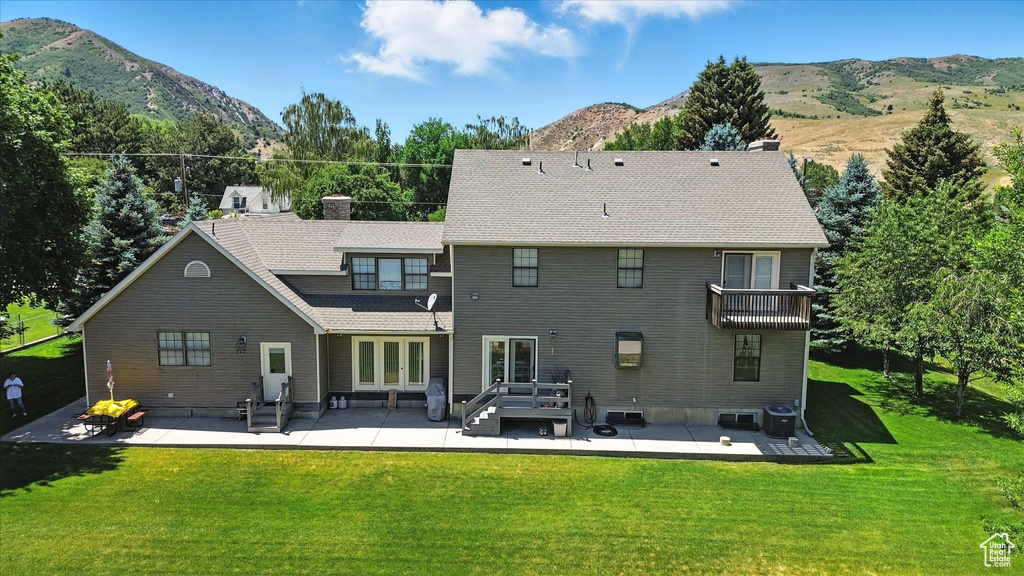 Rear view of property featuring a patio area, french doors, a mountain view, and a chimney