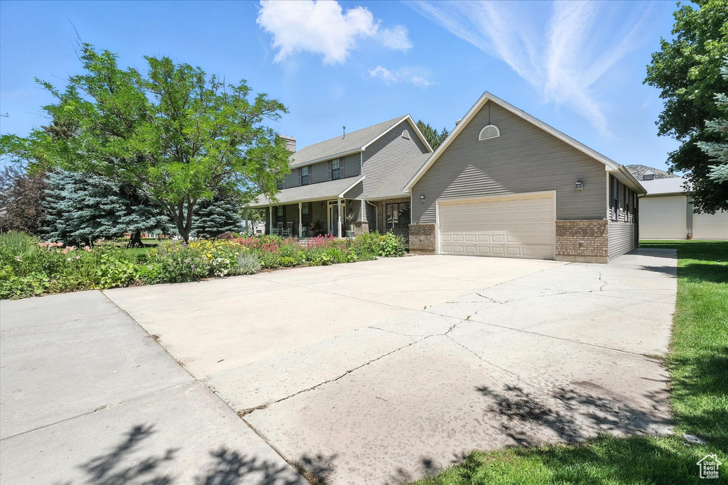 View of front of house with brick siding, a garage, and driveway