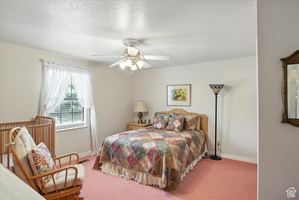 Bedroom featuring carpet, ceiling fan, and a textured ceiling