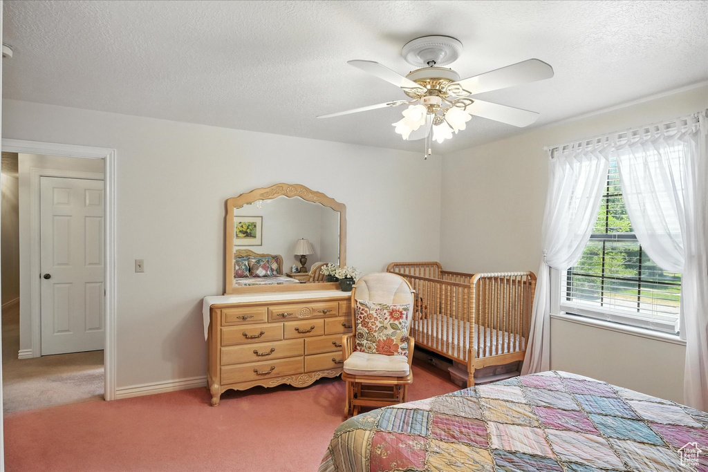 Bedroom with light carpet, a textured ceiling, and a ceiling fan