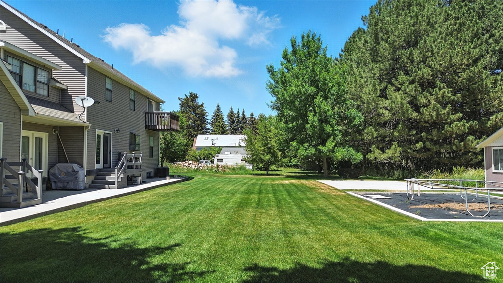 View of green lawn featuring a balcony