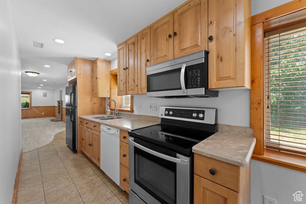 Kitchen featuring appliances with stainless steel finishes, light countertops, recessed lighting, light tile patterned floors, and light brown cabinetry