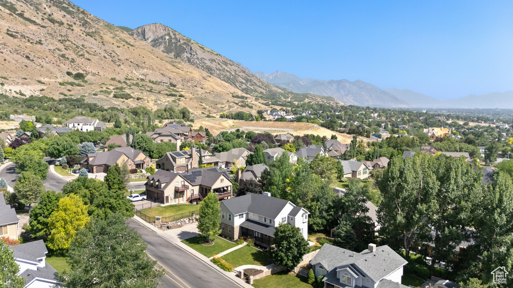 Aerial view of property and surrounding area with nearby suburban area and mountains