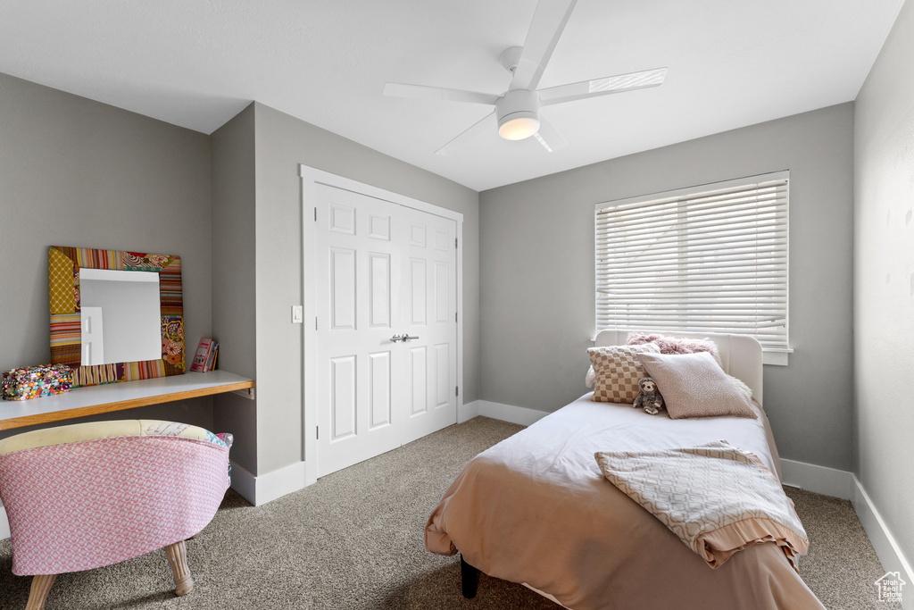 Carpeted bedroom with a ceiling fan and a closet