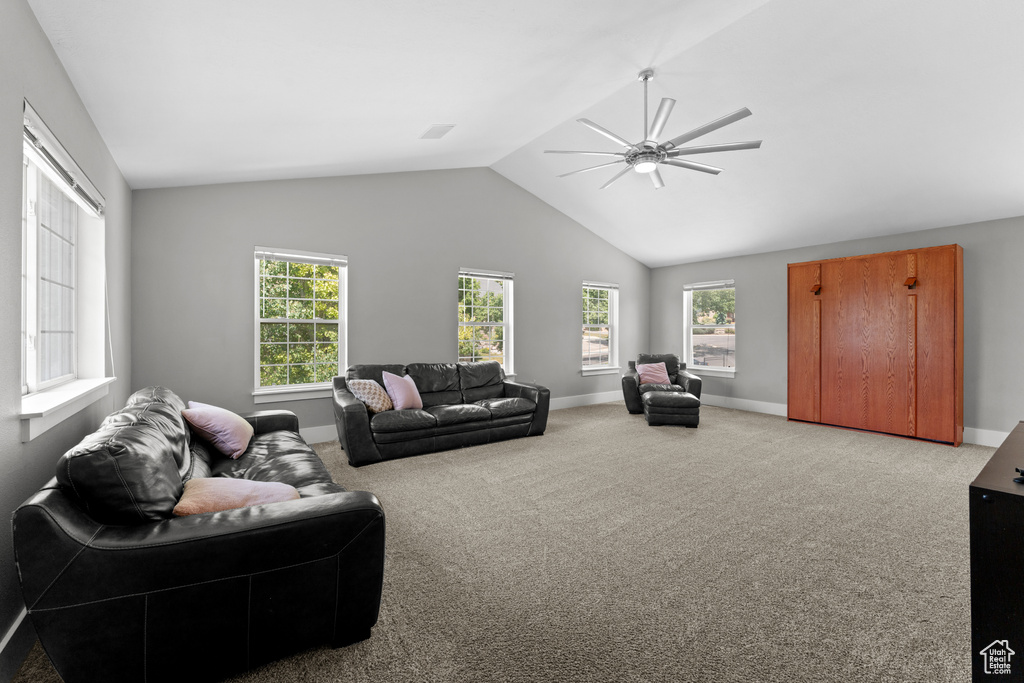 Living room featuring ceiling fan, lofted ceiling, and carpet