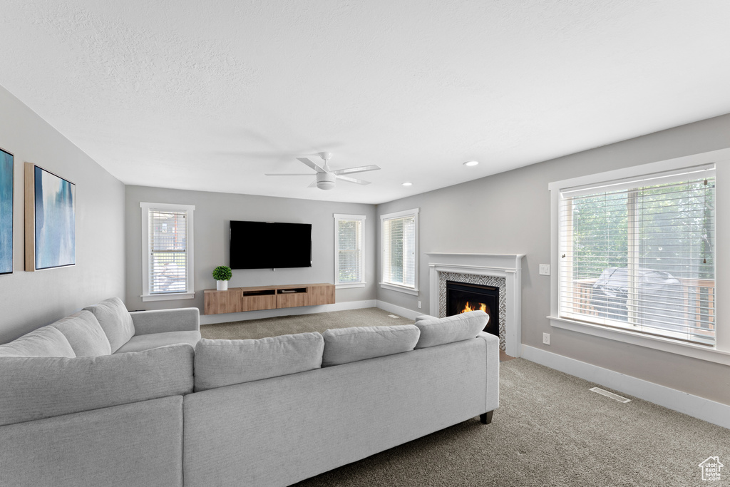 Living room with plenty of natural light, carpet, a ceiling fan, a premium fireplace, and recessed lighting