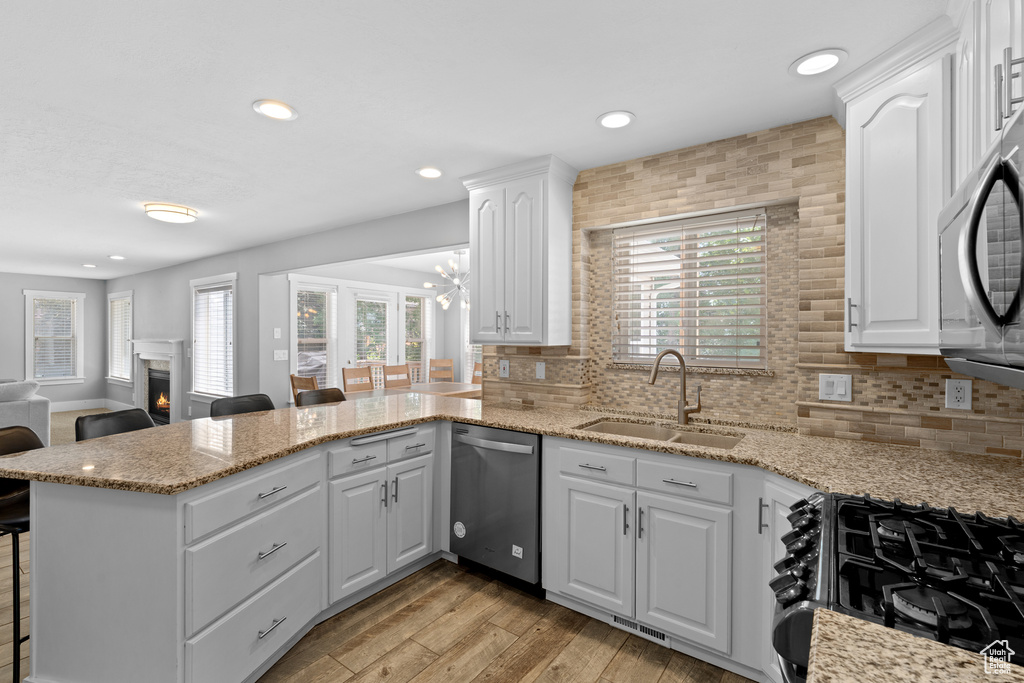 Kitchen featuring stainless steel appliances, a kitchen breakfast bar, healthy amount of natural light, a peninsula, and recessed lighting