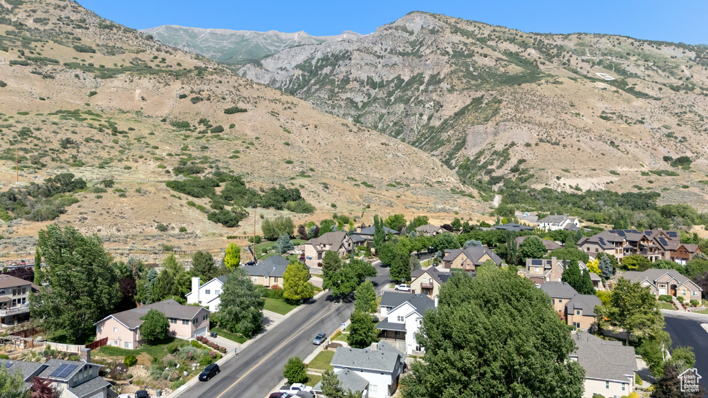 Aerial overview of property\'s location featuring nearby suburban area and a mountainous background